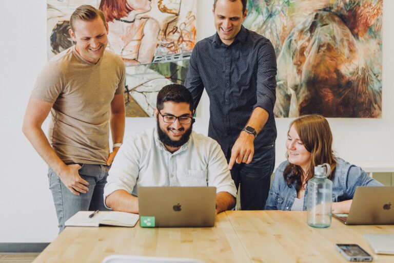 employees on a laptop - Time Doctor Alternatives