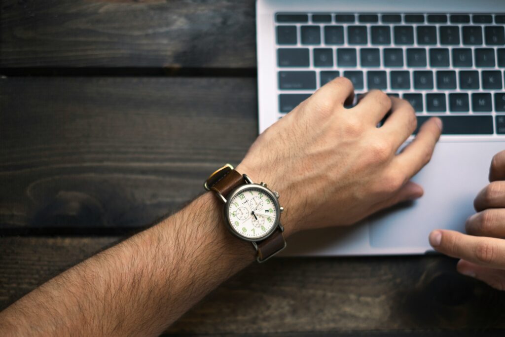 Person Working while Looking at Watch - Time Audit For Employees