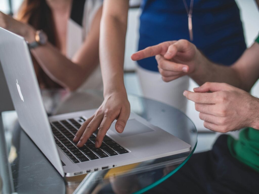 man pointing at a laptop - Monday.com vs Basecamp