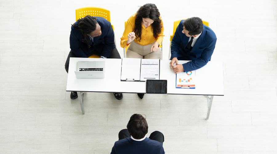 employees conducting an interview - Team Lead Interview Questions