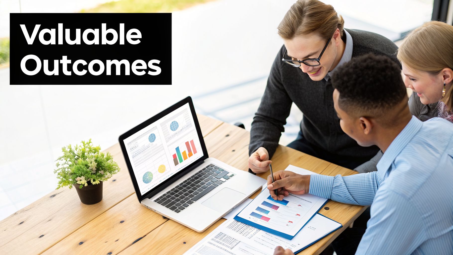 Three professionals analyze data on a laptop and documents, discussing valuable outcomes in a team meeting.