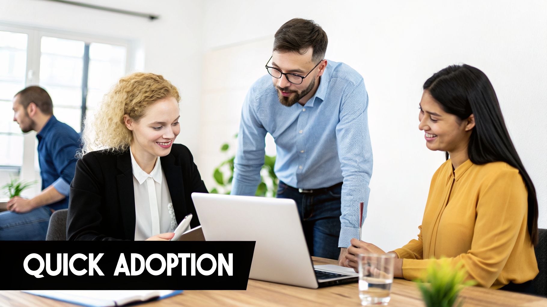 Smiling diverse business professionals collaborating around a laptop in a bright, modern office environment.