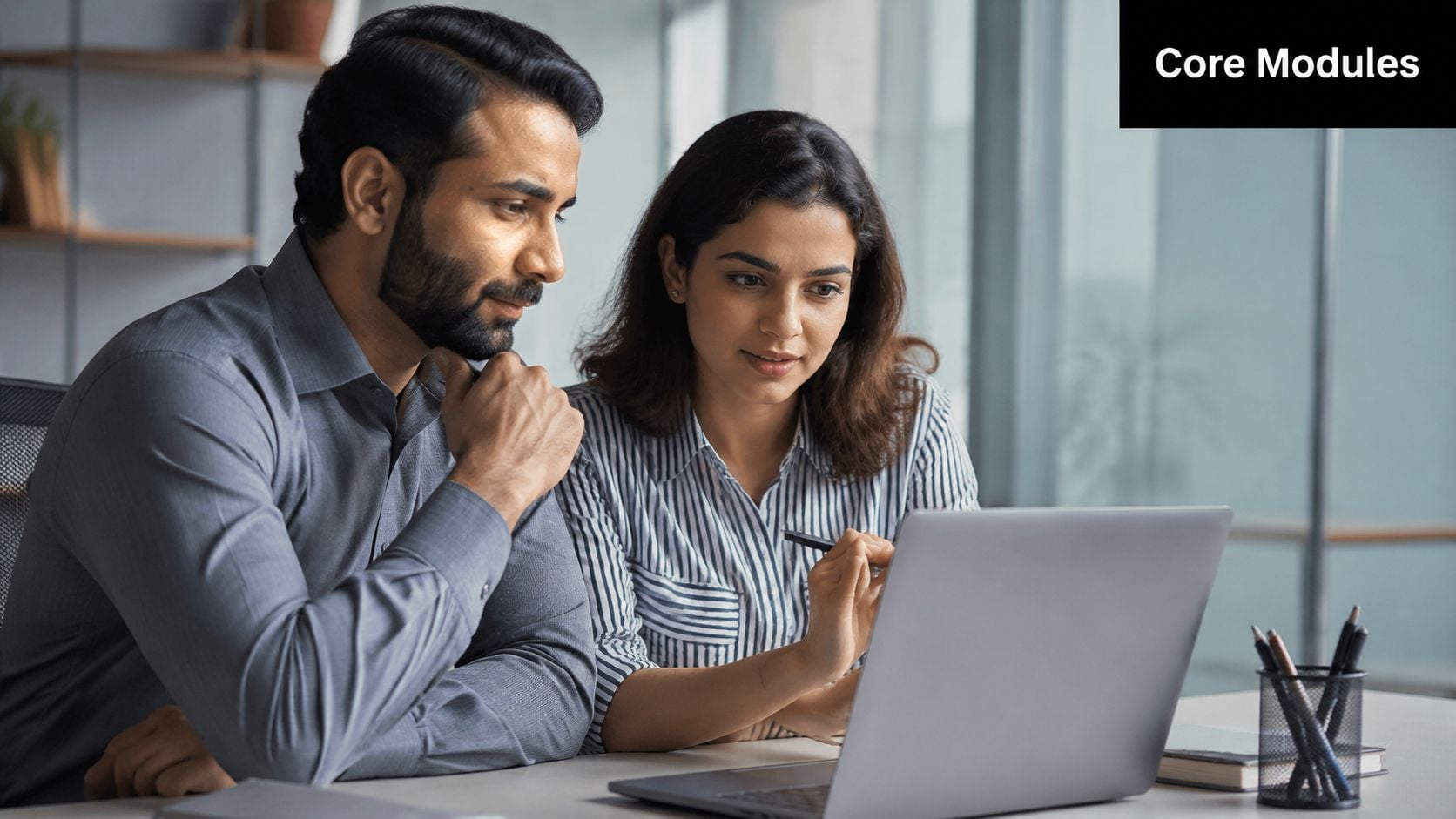 A professional man and woman collaborating together on a laptop project in a modern office workspace.